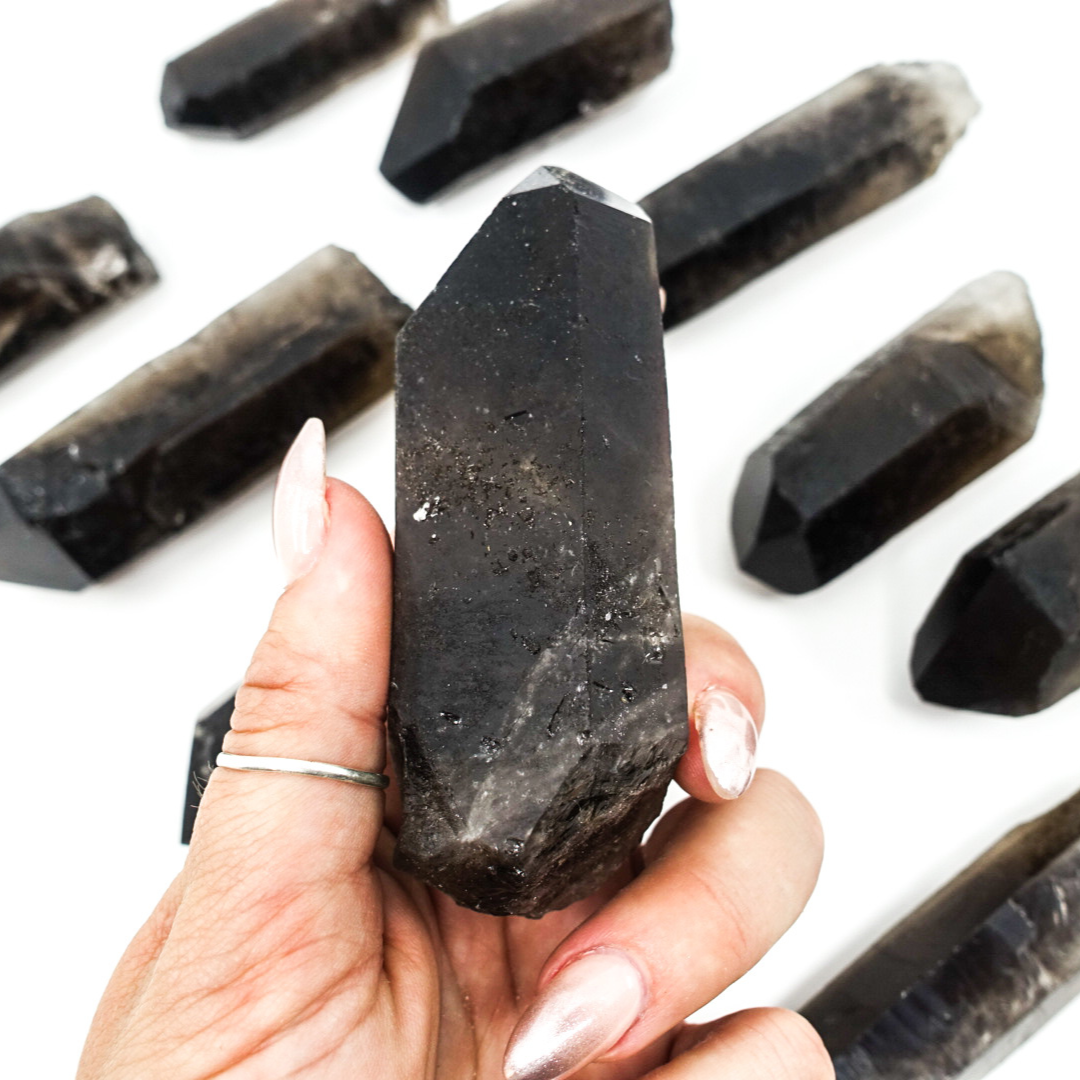 Smoky Quartz points, approximately 2.5"-4.5" in size, known for their grounding and aura purification properties.