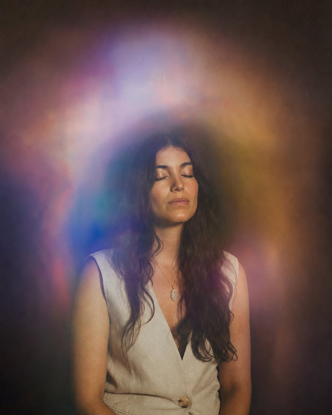 Editorial aura portrait surrounded by soft violet, blue, amber, and rose color